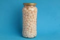 Closeup shot of a jar of dried beans on a blue background Royalty Free Stock Photo