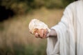 Closeup shot of Jesus Christ handing out bread with a blurred background