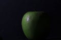 Closeup shot of a juicy apple with waterdrops isolated on a black background Royalty Free Stock Photo