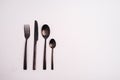 Closeup shot of a knife, fork, and two spoons isolated on a light-colored background Royalty Free Stock Photo