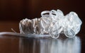 Closeup shot of a lace bridal garter on a reflective surface