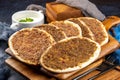 Closeup shot of Lahm Bi Ajeen flatbread with spicy beef meat on a wooden cutting board Royalty Free Stock Photo