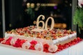 Closeup shot of a large square 60th birthday cake with flowers