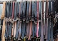 Closeup shot of leather belts hanging on a wooden stick being sold in a marketplace Royalty Free Stock Photo