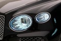 Closeup shot of a light of a black modern Bentley Bentayga 2022 Hybrid badge