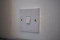 Closeup shot of a light switch on a white wall Royalty Free Stock Photo