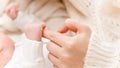 Closeup shot of little newborn baby hand holding big finger of young mother