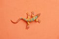 Closeup shot of lizard shaped rubber toy isolated on an orange background