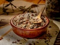 Closeup shot of long grain wild rice in a plate with a wooden spoon on a piece table cover Royalty Free Stock Photo