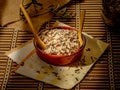 Closeup shot of long grain wild rice in a plate with wooden spoons on a piece table cover Royalty Free Stock Photo