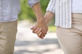 Closeup shot of loving mature couple holding hands while walking together outdoors Royalty Free Stock Photo