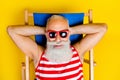 Closeup shot of lying sunbed funny chilling cool pensioner gray bearded man take nap at local beach isolated over yellow