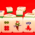 Closeup shot of mahjong game tiles in front of a red background