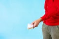 Closeup shot of a male holding a bunch of large Euro bills on a blue background