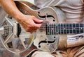 Closeup shot of a male playing the silver iron guitar