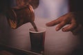 Closeup shot of a male pouring out Turkish coffee into a cup Royalty Free Stock Photo