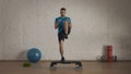 Closeup shot. Man fitness trainer in sportswear doing high knee jumps on step board exercise. Royalty Free Stock Photo