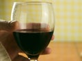 Closeup shot of a man holding a glass of red wine on a blurred background Royalty Free Stock Photo