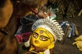 Closeup shot of a man painting the face of Goddess Durga in preparations for the Durga Puja festival