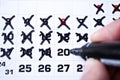 Closeup shot of a man pointing the days of the month in the calendar