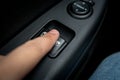 Closeup shot of man pressing button controlling window in car Royalty Free Stock Photo