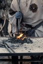 Closeup shot of the medieval blacksmith at work with glowing irons Royalty Free Stock Photo