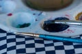 Closeup shot of a messy white paint palette with paint and brushes Royalty Free Stock Photo