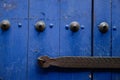 Closeup shot of the metal bolts and handle on a blue wooden door Royalty Free Stock Photo