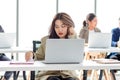 Closeup shot of millennial Asian young stressed depressed sleepy female businesswoman employee sitting holding hand on messy hair Royalty Free Stock Photo