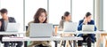 Closeup shot of millennial Asian young stressed depressed sleepy female businesswoman employee sitting holding hand on messy hair Royalty Free Stock Photo