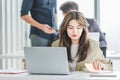 Closeup shot of millennial Asian young stressed depressed sleepy female businesswoman employee sitting holding hand on messy hair Royalty Free Stock Photo