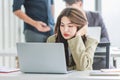 Closeup shot of millennial Asian young stressed depressed sleepy female businesswoman employee sitting holding hand on messy hair Royalty Free Stock Photo