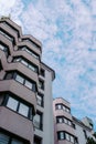 Closeup shot of a modern business building touching the fluffy cloudy sky Royalty Free Stock Photo