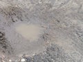 A closeup shot of a muddy puddle in a cracked road