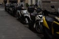 Closeup shot of multiple scooter bikes lined up on the side of the street