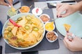 Closeup shot of nachos with chillies on a bowl with different kinds of dip on the side