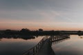 Closeup shot of a narrow bridge dock above the lake at sunset Royalty Free Stock Photo