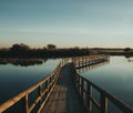 Closeup shot of a narrow bridge dock above the lake at sunset Royalty Free Stock Photo