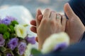 Closeup shot of new-married couple hands on a beautiful wedding bouquet background Royalty Free Stock Photo