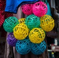 Closeup shot of numerous colorful hanging plastic balls under the light