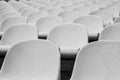 Closeup shot of numerous rows of white plastic chairs Royalty Free Stock Photo