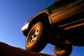 A closeup shot of a offroad racing car powering through a deep muddy hole its wheels spinning at speed. Speed drive