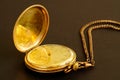 Closeup shot of an old gold-plated pocket watch against a brown background Royalty Free Stock Photo