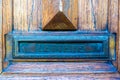 Closeup shot of an old iron mailbox flap built into an old door Royalty Free Stock Photo