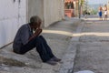 Closeup shot of an old male in true poverty sitting on ground outdoors in Matanzas in Cuba