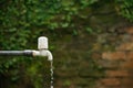 Closeup shot of an old outdoor water faucet and water drops leaking from it Royalty Free Stock Photo