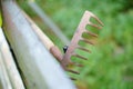 Closeup shot of an old rake behind a wooden fence Royalty Free Stock Photo