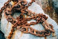 Closeup shot of an old rusty chains placed on the rock Royalty Free Stock Photo