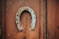 Closeup shot of an old rusty horseshoe hanging on a wooden door