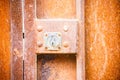 Closeup shot of an old rusty keyhole on an orange door Royalty Free Stock Photo